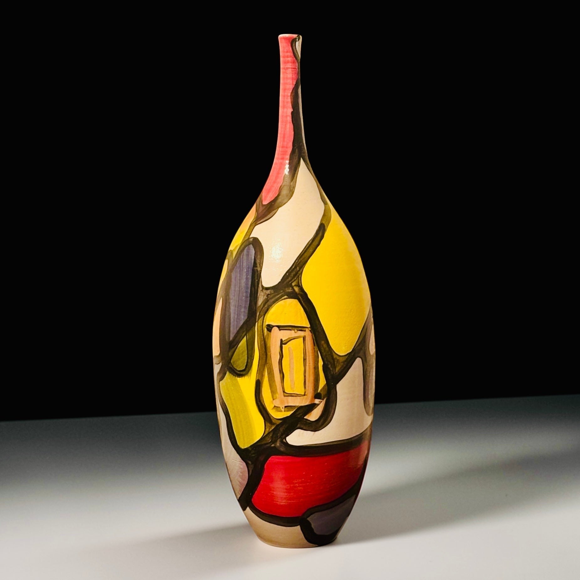 CeramicMeltdown.com abstract art vase with yellow, red, and black geometric patterns. Tall, slender neck.