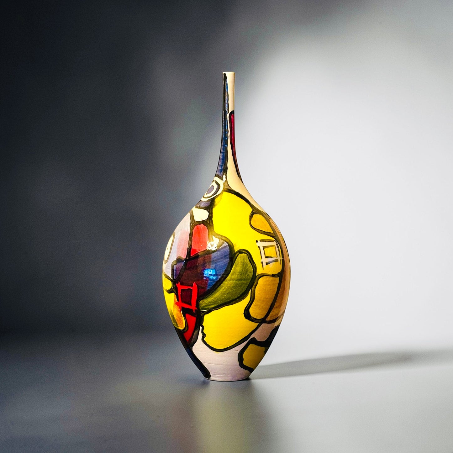 CeramicMeltdown.com Archipelago vase, white stoneware with glossy glaze, hand-painted abstract design in yellow, red, blue, green, and brown.