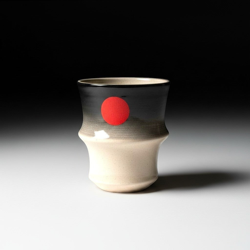 CeramicMeltdown.com Red Sun Tumbler, beige to charcoal grey gradient ceramic with red sun motif, ergonomic shape.
