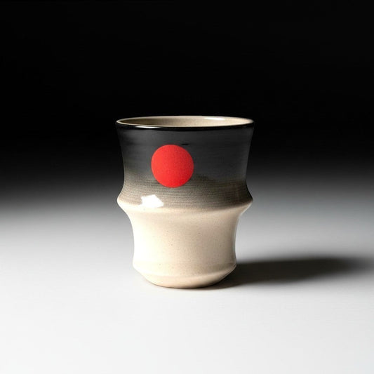 CeramicMeltdown.com Red Sun Tumbler, beige to charcoal grey gradient ceramic with red sun motif, ergonomic shape.