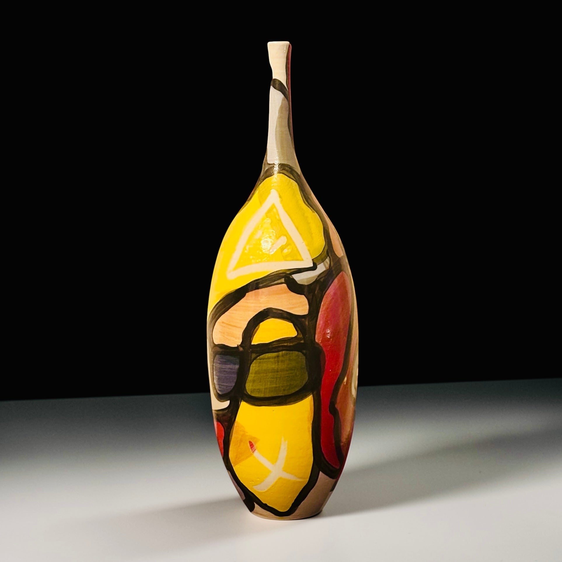 CeramicMeltdown.com abstract yellow vase with bold black outlines and colorful geometric shapes. Tall, slender neck.