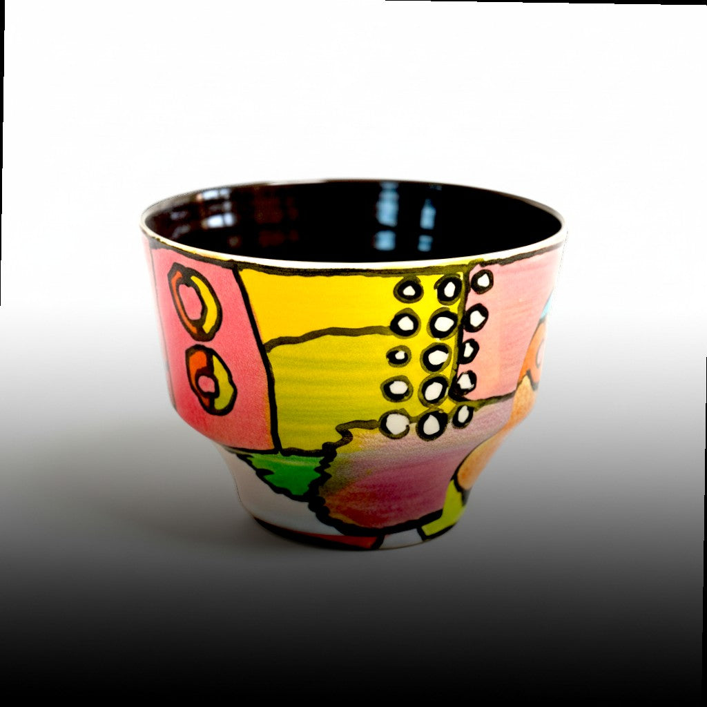 CeramicMeltdown.com hand-painted ceramic cup with abstract colorful design in pink, yellow, and green.