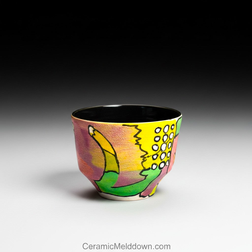 CeramicMeltdown.com hand-painted ceramic cup with abstract colorful design in yellow, pink, green, and purple. Features textured surface and black interior.