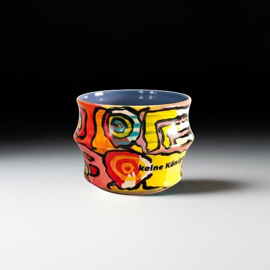 CeramicMeltdown.com abstract art mug with yellow, orange, red, blue design and German text "keine König".