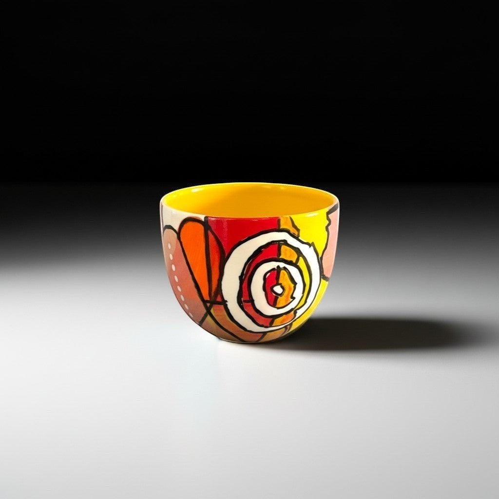 CeramicMeltdown.com abstract art wine cup with yellow interior and vibrant red, orange, and brown painted design.