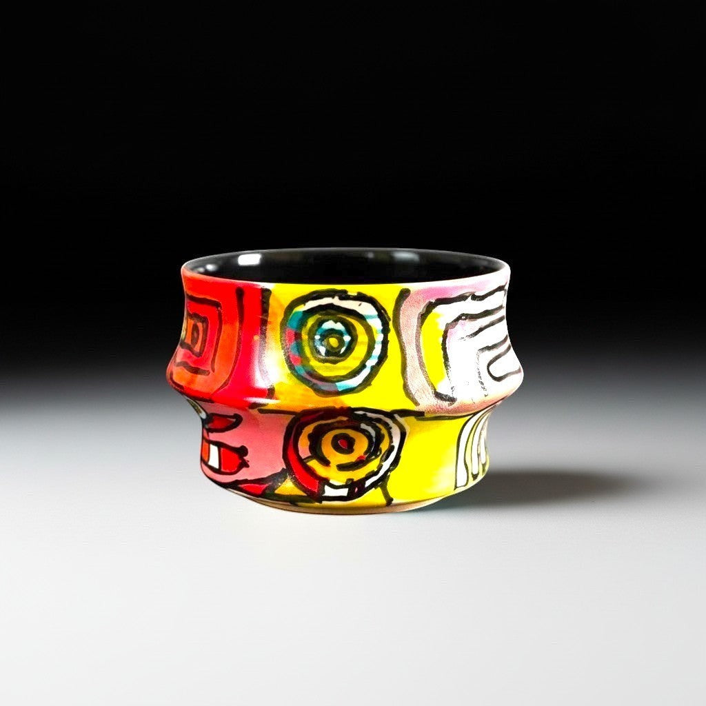 CeramicMeltdown.com Freedom Cup, a vibrant ceramic vessel with a colorful abstract design in red, yellow, and black.