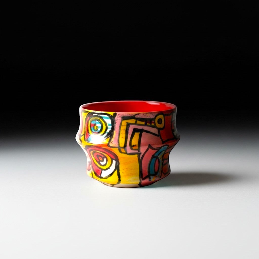 CeramicMeltdown.com Freedom Cup, a vibrant, abstractly painted ceramic vessel with a red interior and a unique, undulating shape.