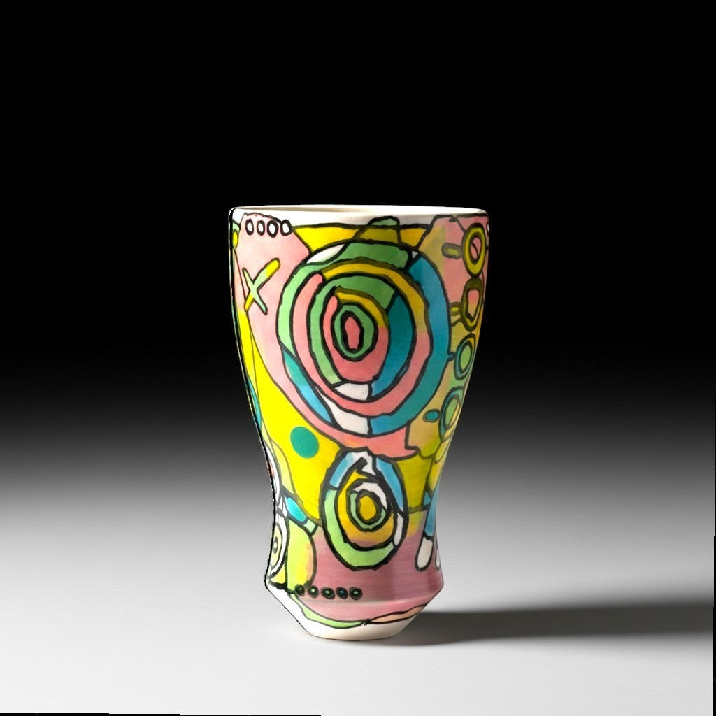 CeramicMeltdown.com Bill Vase, a vibrant, abstract ceramic vase with a pink base, yellow, green, and blue swirling patterns, and black outlines.